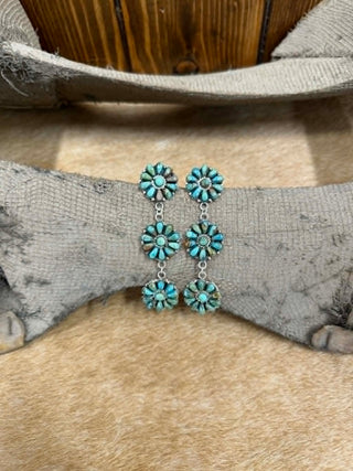 stamped Turquoise floral earrings on a textured surface