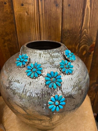 Decorative vase with turquoise floral patterns against a wooden background