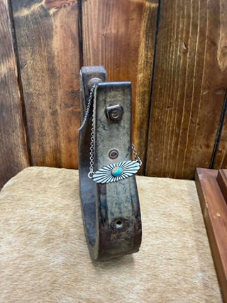 Metal necklace with a turquoise pendant on a wooden surface