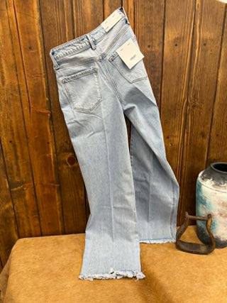 Light blue jeans with a tag on a wooden surface