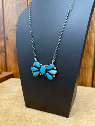 authentic turquoise Necklace with blue stones on a black stand against a wooden background