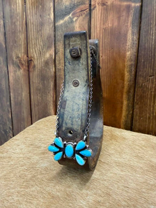 Necklace with turquoise flowers on a rustic wooden background