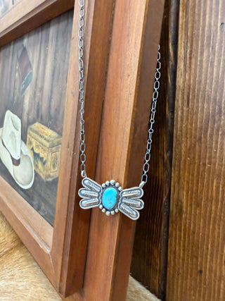 Necklace with a turquoise pendant on a wooden surface