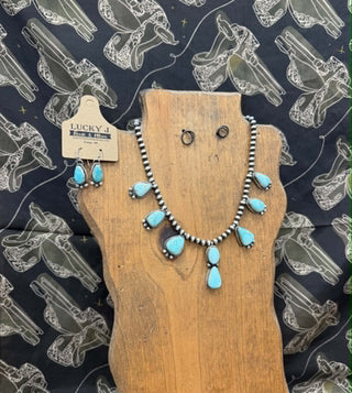 authentic turquoise necklace set on a women with a wooden background